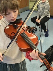 A girl concentrates as she plays the viola